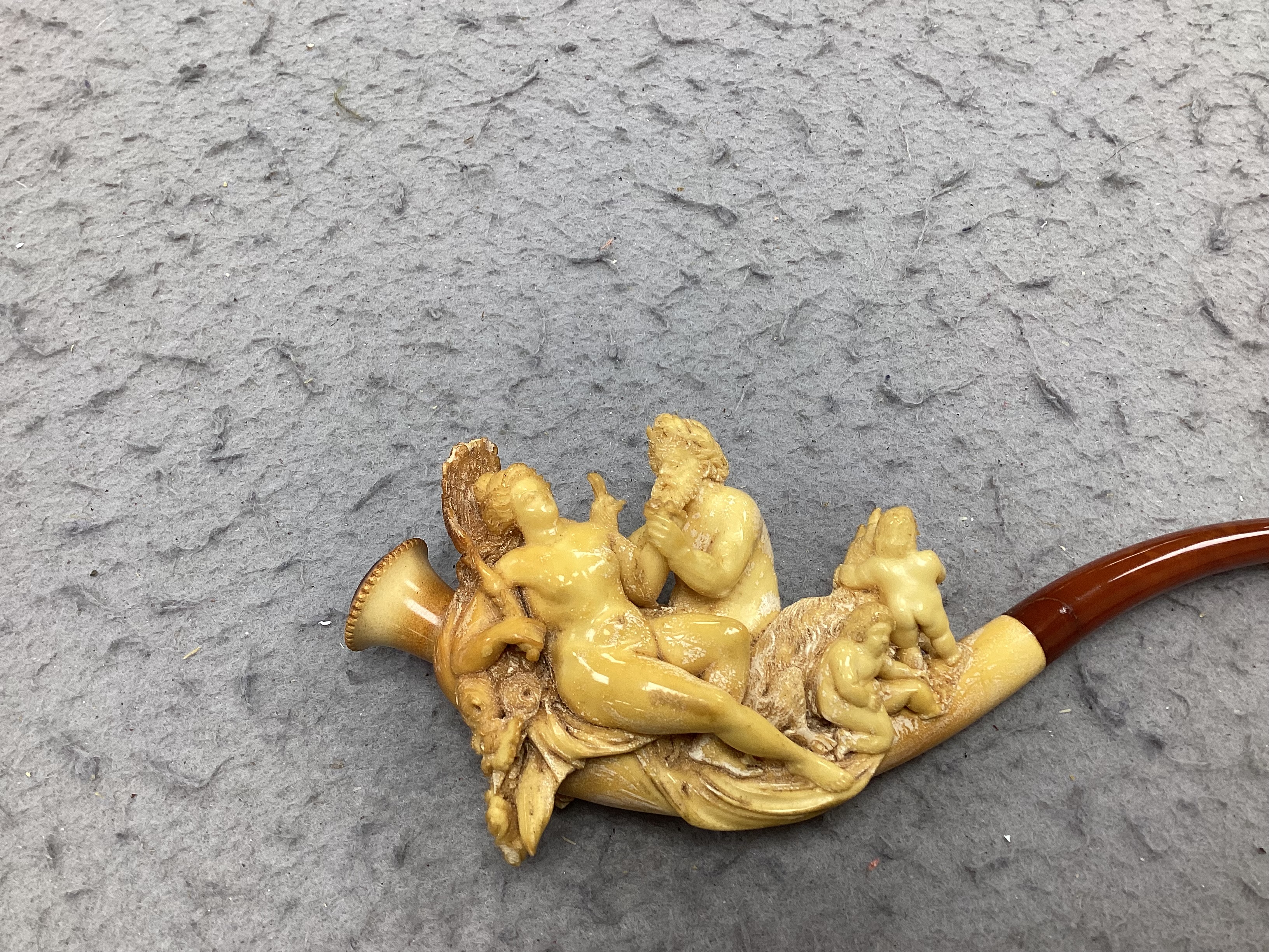 A cased ornate Meerschaum pipe, early 20th century, intricately carved with the figures of Mars and Rhea Silvia with Romulus and Remus and the wolf on the bowl, 18cm long